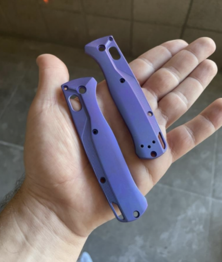 一只手握着两个由阳极氧化钛制成的紫色工具手柄.
